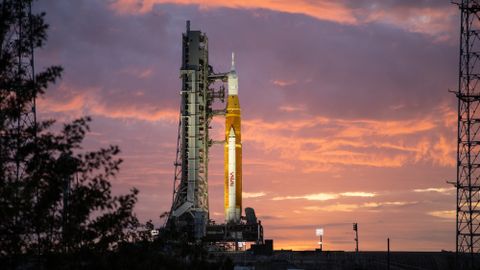 giant rocket on launch pad with clouds at sunrise