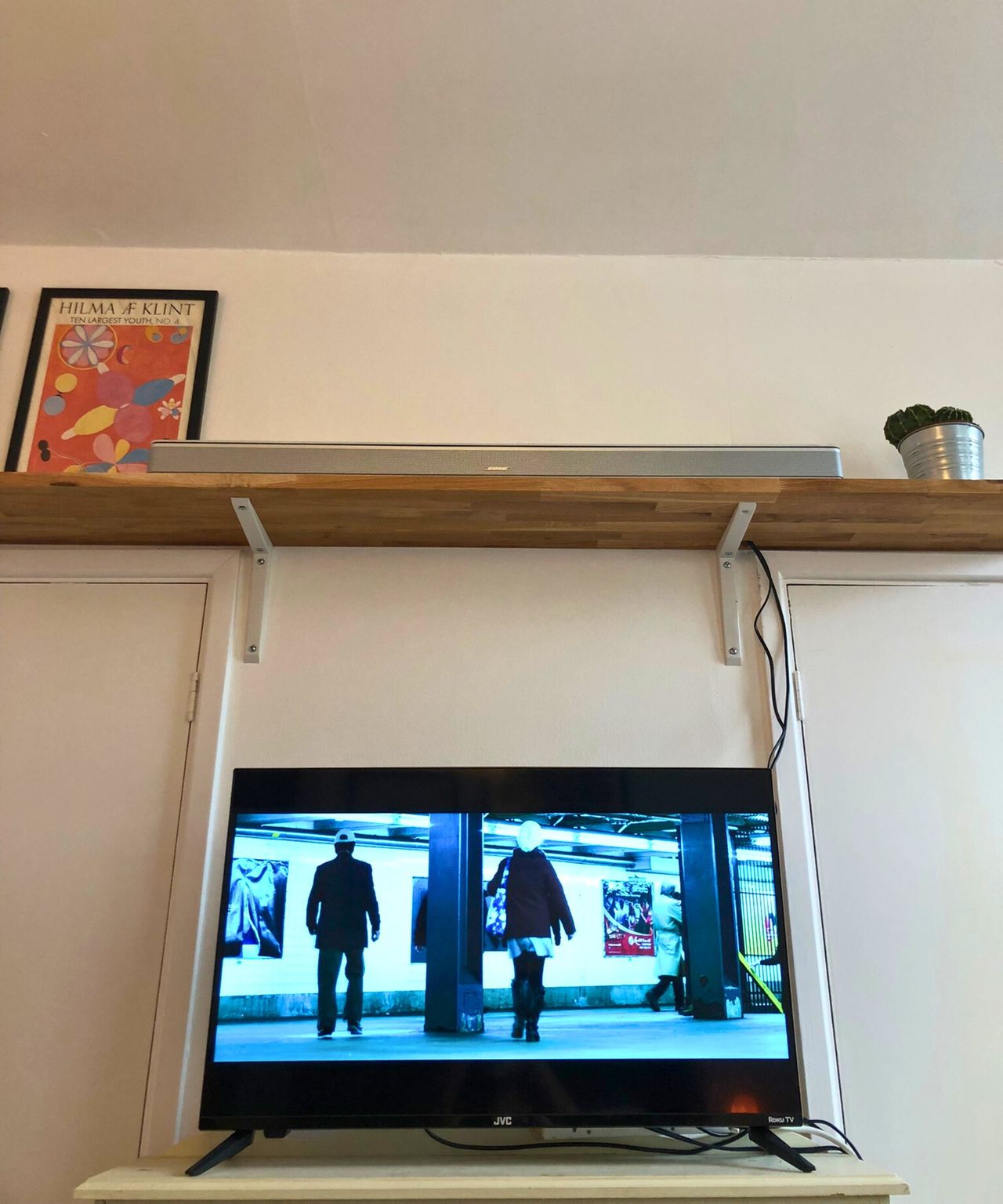 The Bose Smart Ultra Soundbar on wooden shelf above TV showing John Wick Chapter 2 in Dan Fauzi's home.