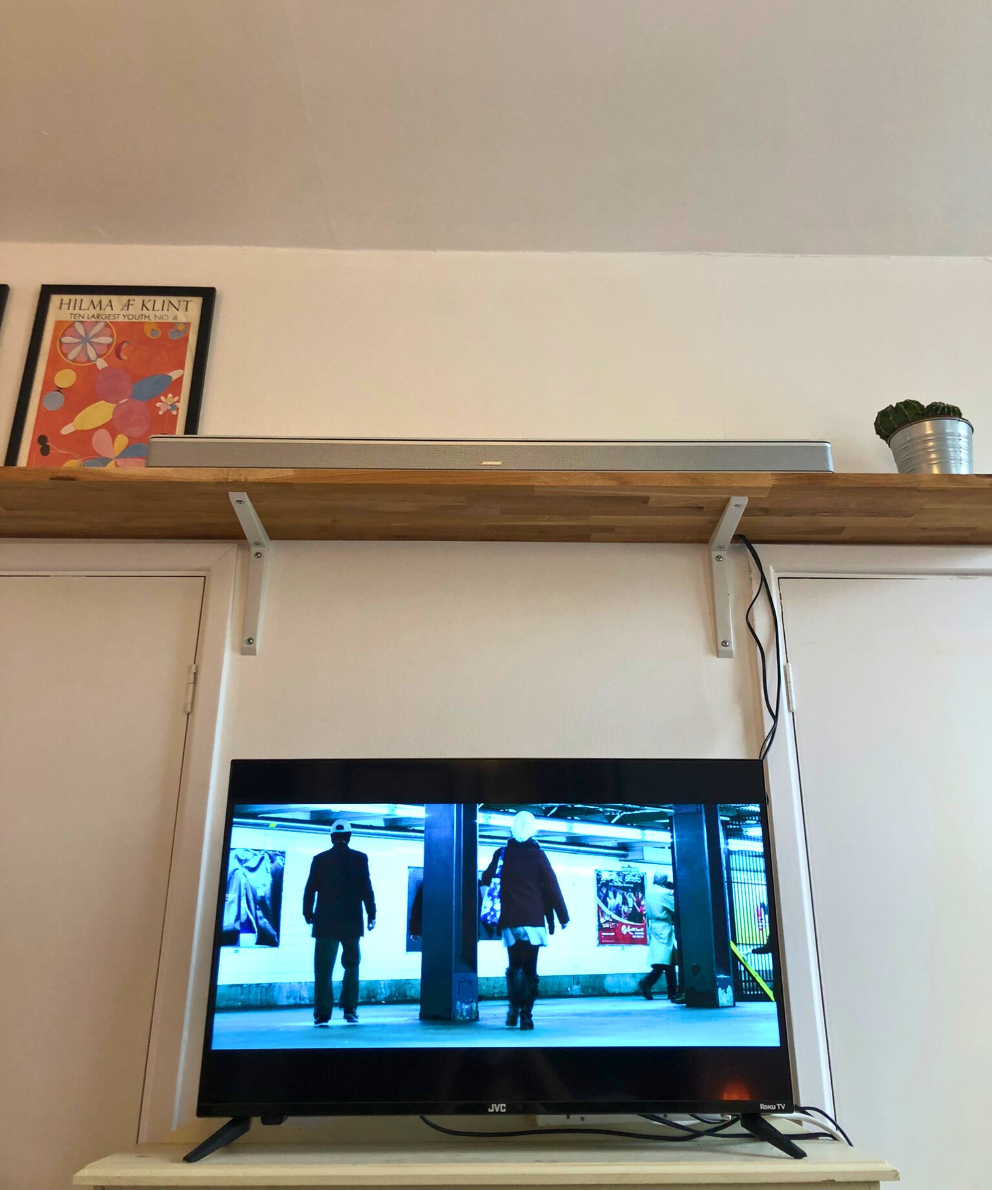 The Bose Smart Ultra Soundbar on wooden shelf above TV showing John Wick Chapter 2 in Dan Fauzi's home.