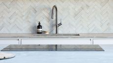 close up of induction hob with tap and sink in the background