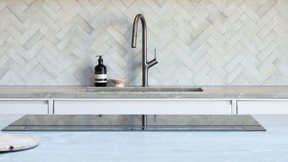 close up of induction hob with tap and sink in the background