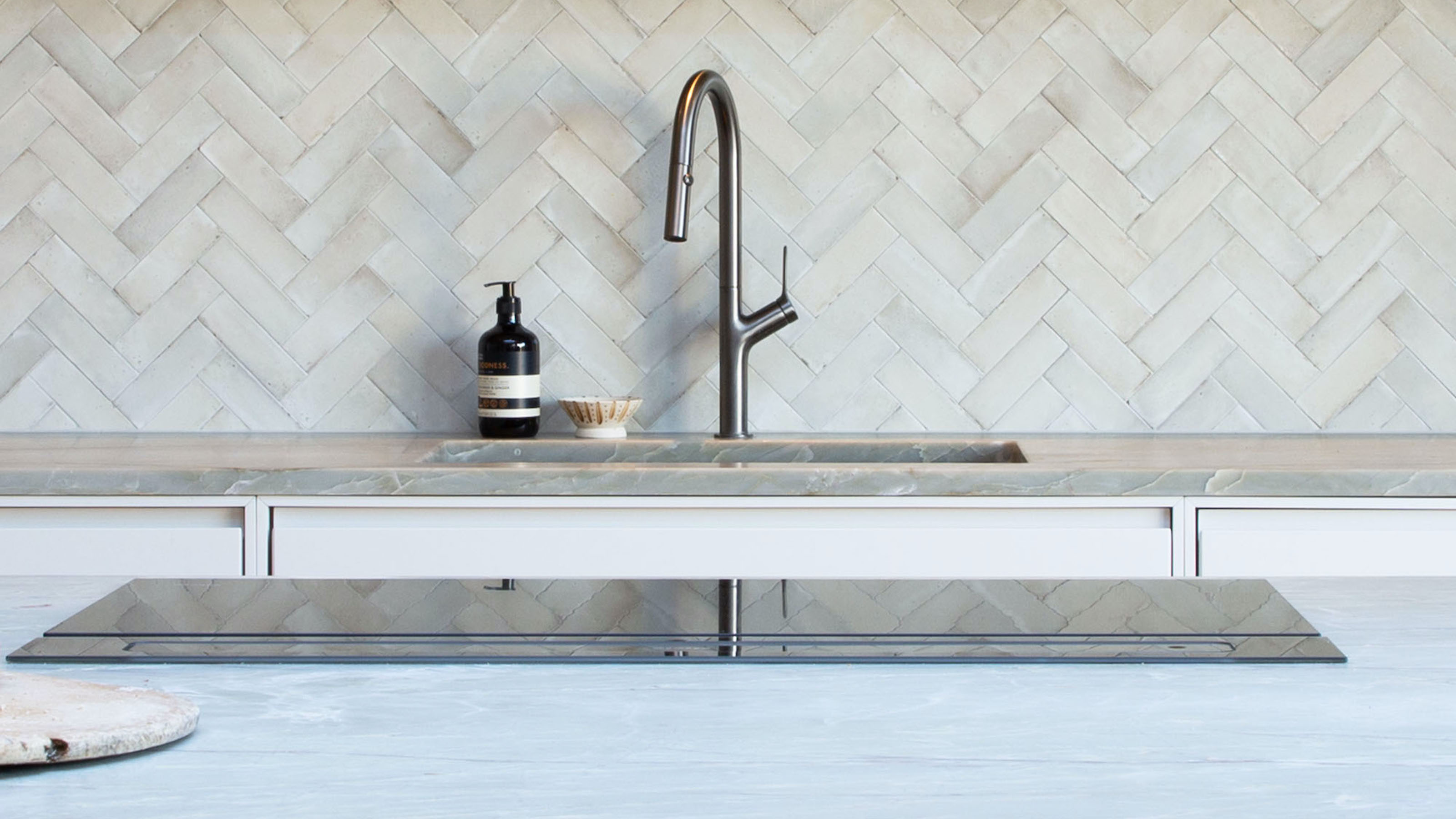 close up of induction hob with tap and sink in the background