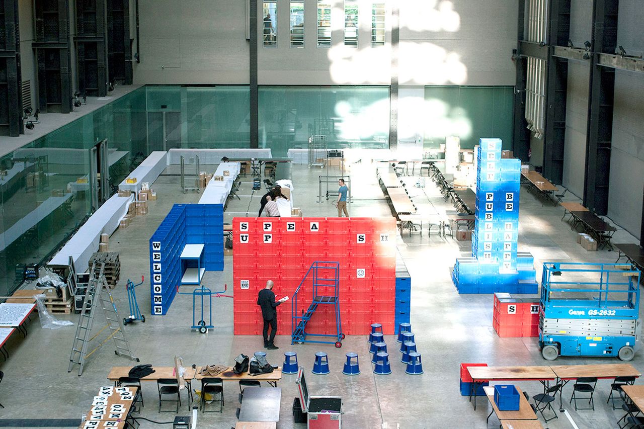 Turbine Hall with plastic boxes and people as the workshop is set-up