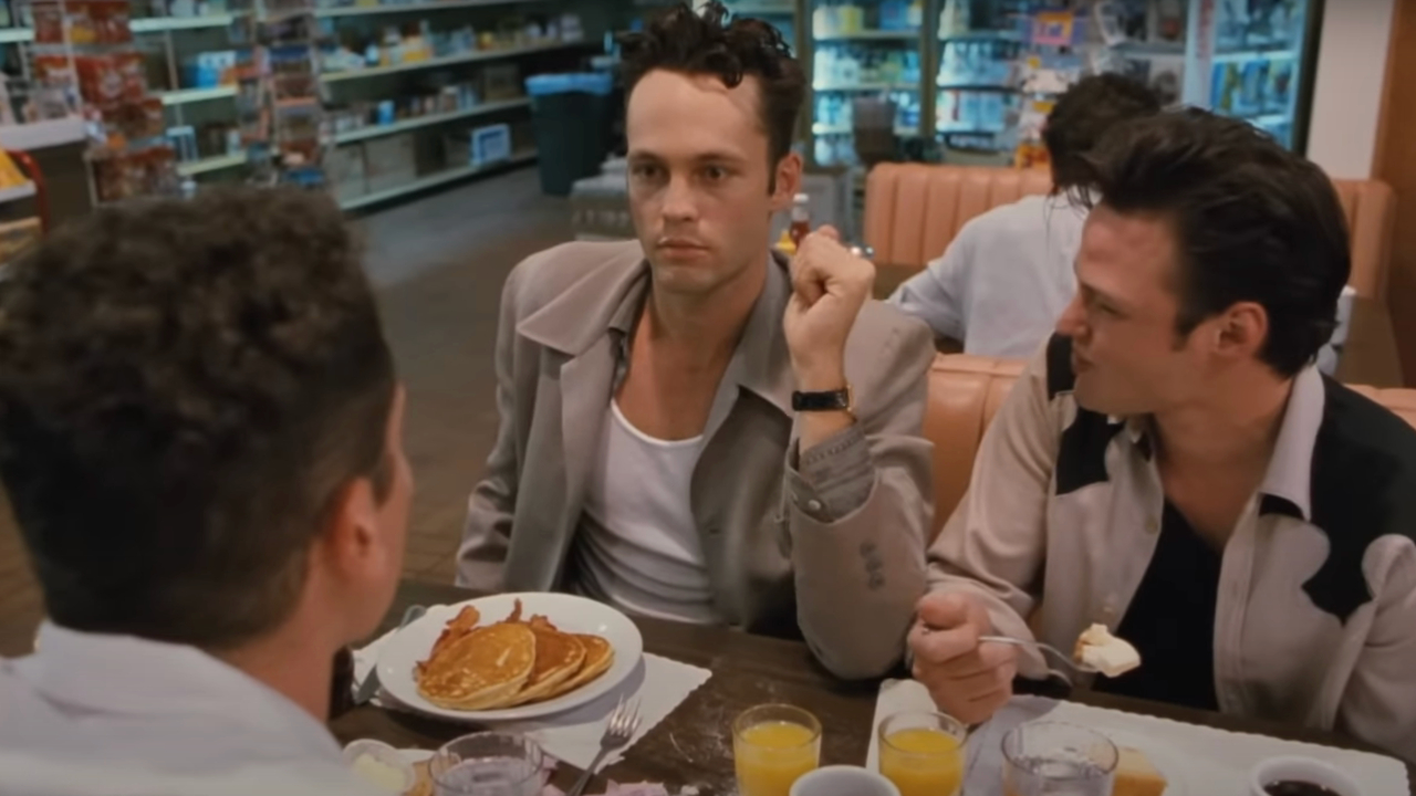 Vince Vaughn sitting with a look of upset during a meal in Swingers.