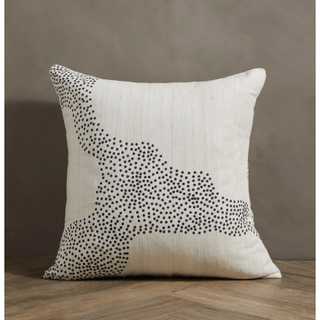 cream pillow with a black dotted pattern