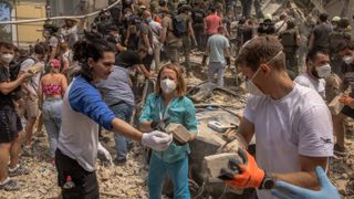 TOPSHOT - Volunteers, including medics, help emergency and rescue personnel to clear the rubble of a destroyed building at Ohmatdyt Children's Hospital following a Russian missile attack in the Ukrainian capital of Kyiv on July 8, 2024, amid the Russian invasion in Ukraine.