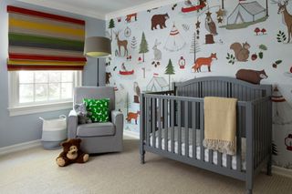 childs room with striped fabric blind and playful wallpaper and gray cot