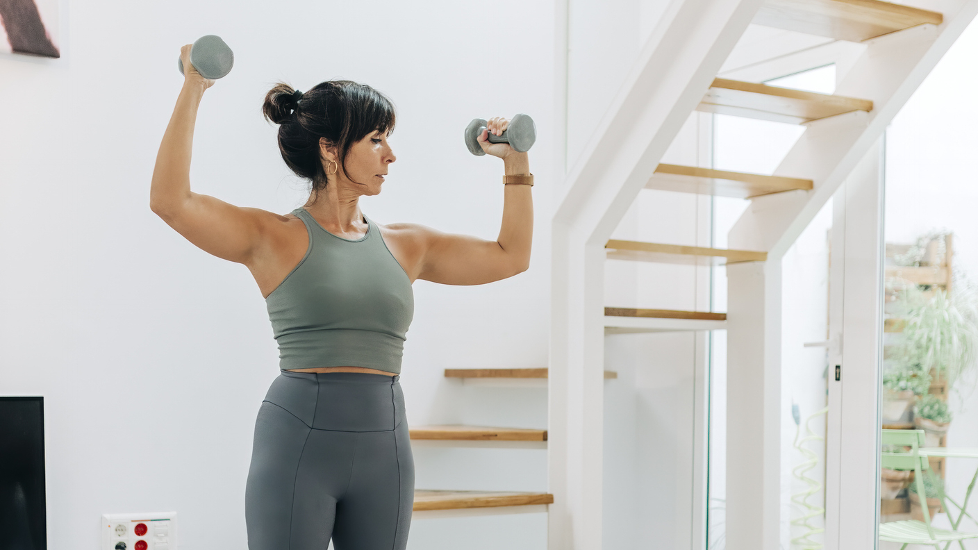 Woman holding dumbbells in a domestic setting