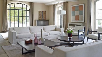 living room with white couches and chairs