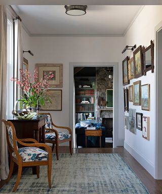 gray entry hall with blue and white patterned armchairs, patterned rug and gallery wall
