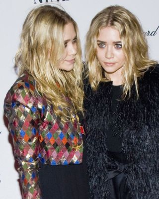 The Olsen twins with matching wavy blonde hair.