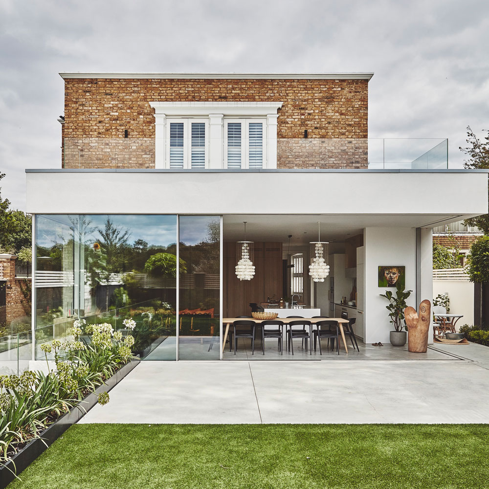 exterior of detached brick house with modern extension, patio and lawn