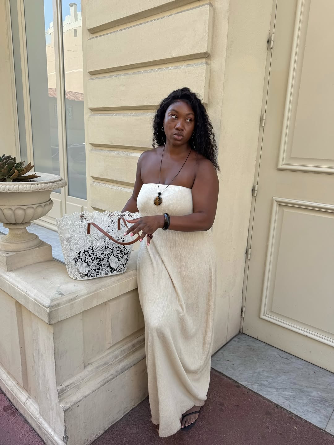 Nnenna in a white sundress with a lace tote