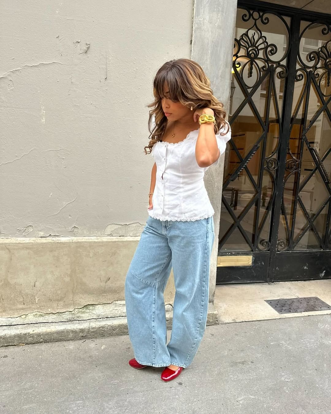 Woman in white top, jeans and cherry red shoes