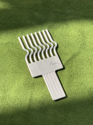 white afropick against a green background