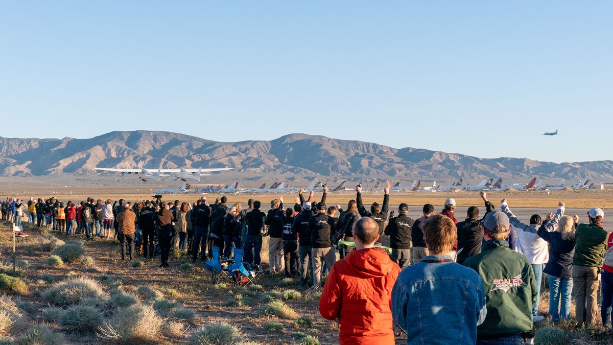 Crowds cheer the first-ever liftoff of Stratolaunch's huge carrier plane Roc on April 13, 2019.