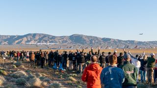 Crowds cheer the first-ever liftoff of Stratolaunch's huge carrier plane Roc on April 13, 2019.