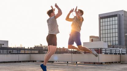 Two men jump up to high five each other