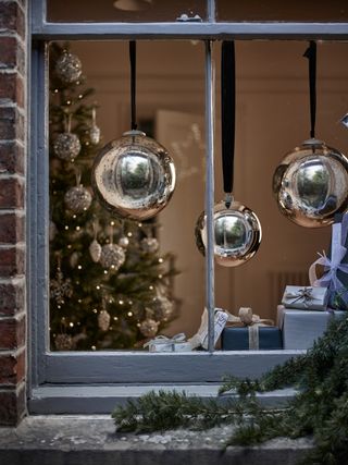 Window display with oversized silver baubles