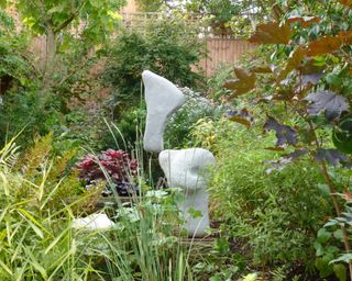 stone balanced sculpture by Adrian Gray in a garden setting