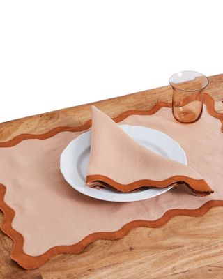 Bed Threads' tableware includes argilla-hued napkins, placemat, glasses, and a white dish.