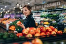 Young woman grocery shopping in the fruit aisle
