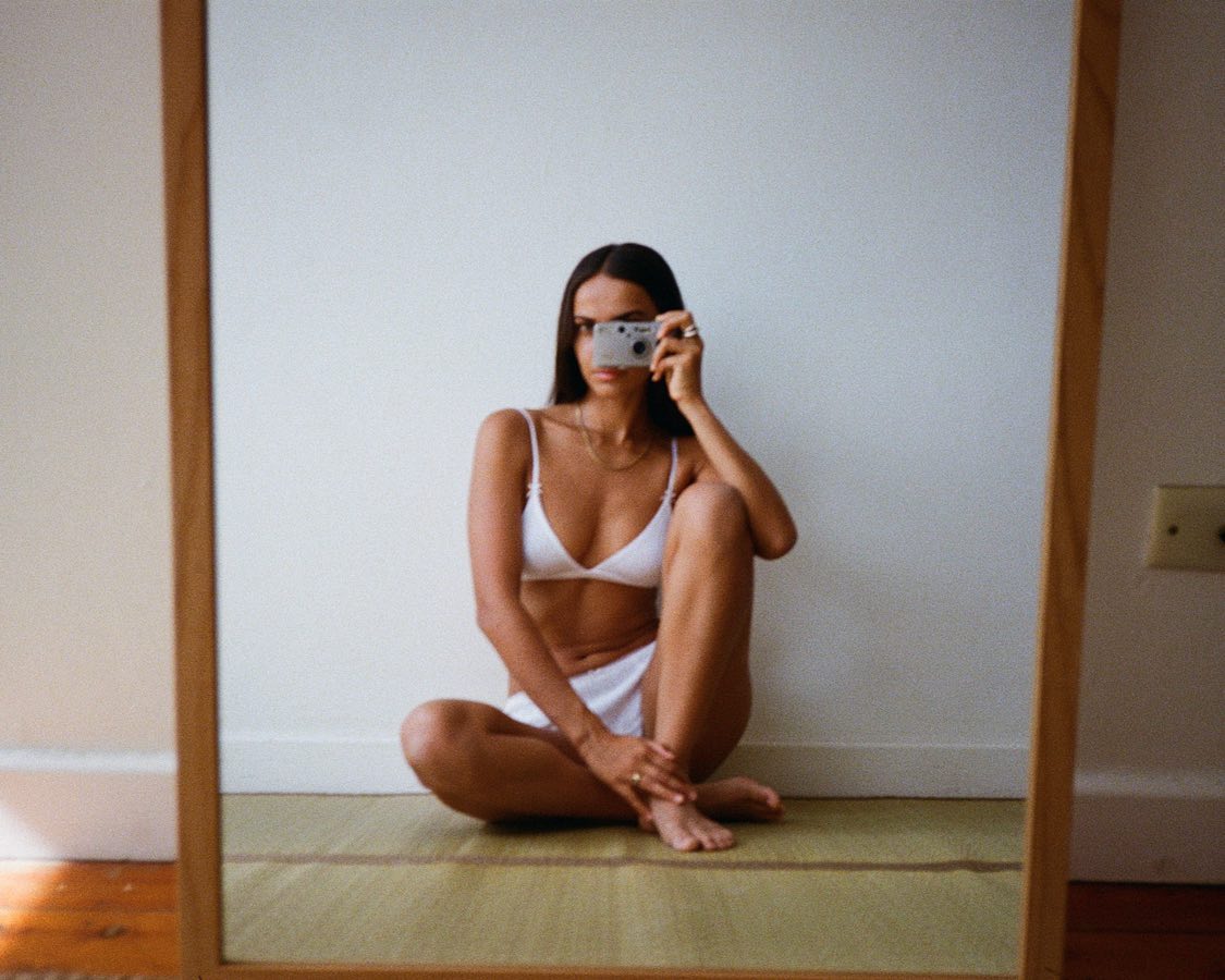 an influencer poses for a mirror selfie in a white bra and boxers from Cou Cou Intimates