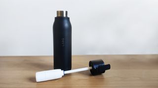 Larq bottle filtered with head and filter lying next to bottle