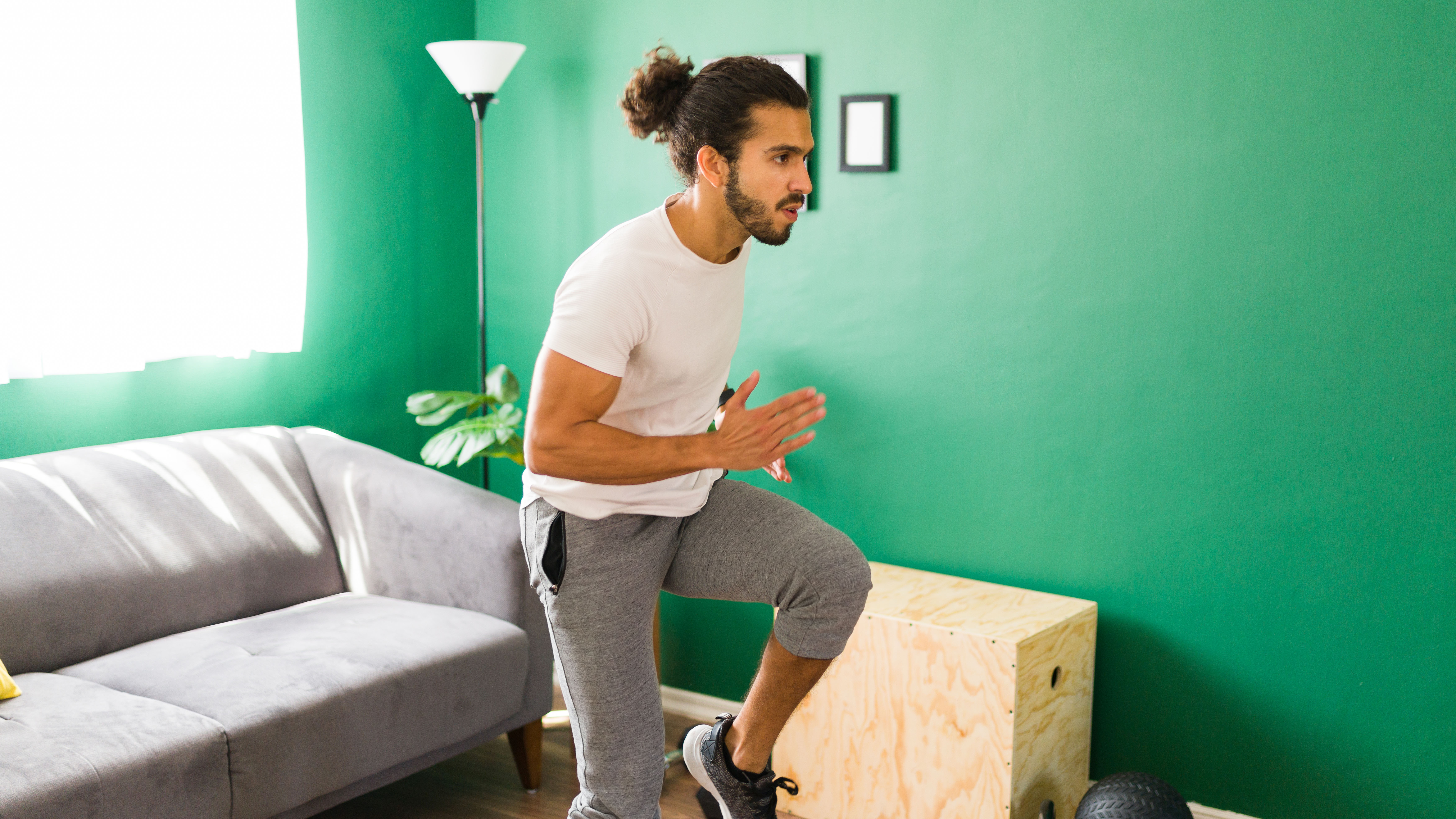 Hombre haciendo régimen de entrenamiento Tabata en la sala de estar