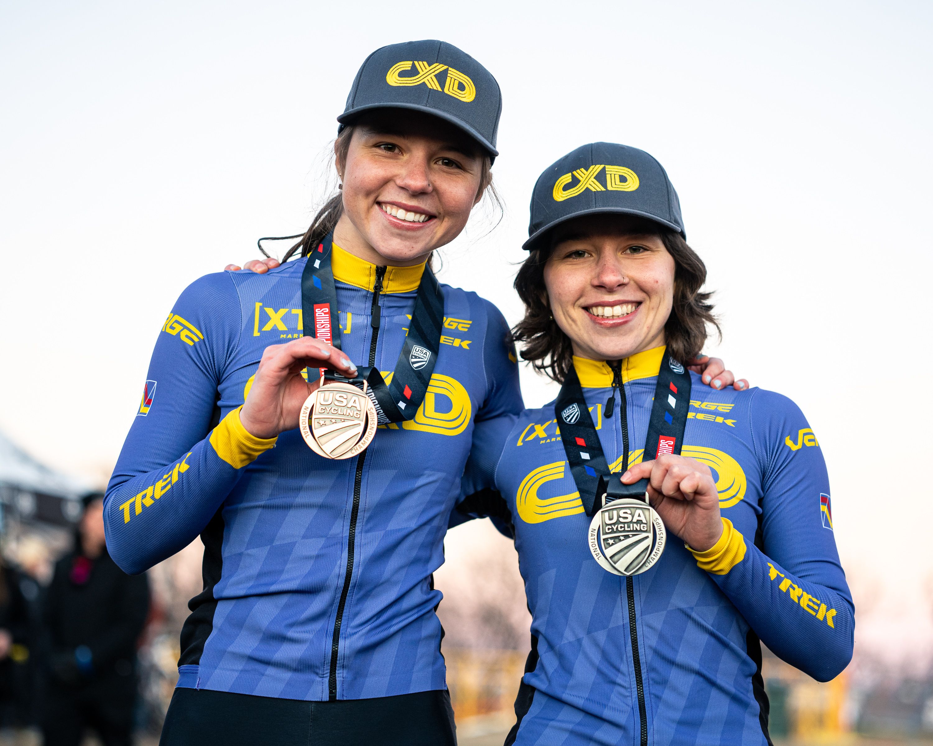 Sarkisov sisters, Katherine on right with silver medal and Alyssa on left with bronze medal, pose with USA Cycling Cyclo-cross Nationals elite women's podium in 2025