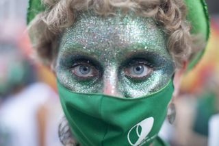 woman in green mask with green glitter over face