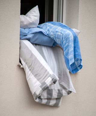 Duvet and bedding airing out of a window
