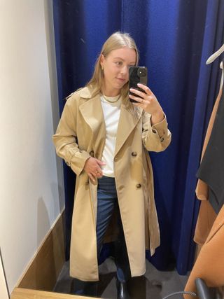 Woman wears beige trench coat, white T-shirt and bleu jeans