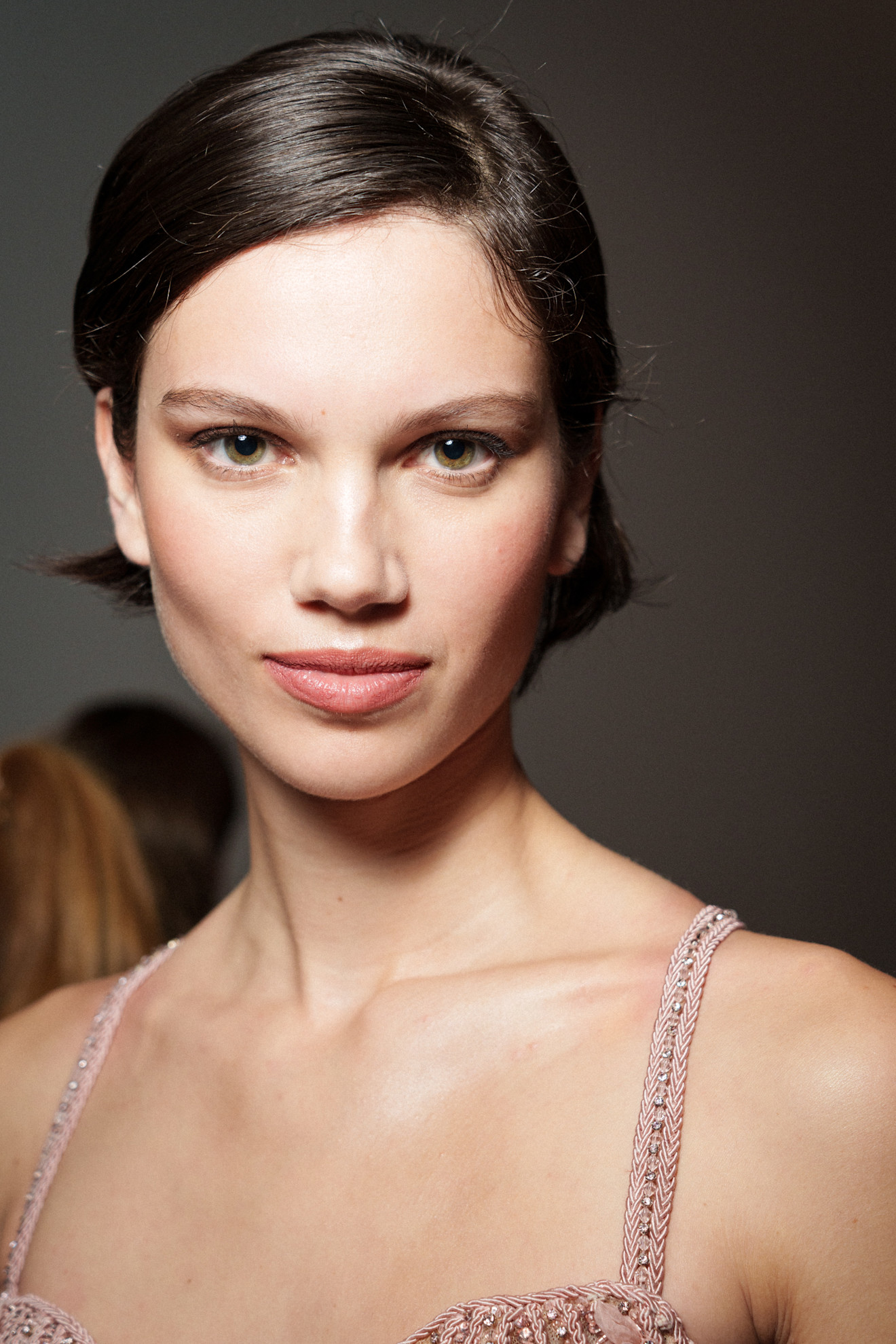 A model showing off a bixie cut, with her hair tucked behind the ears.