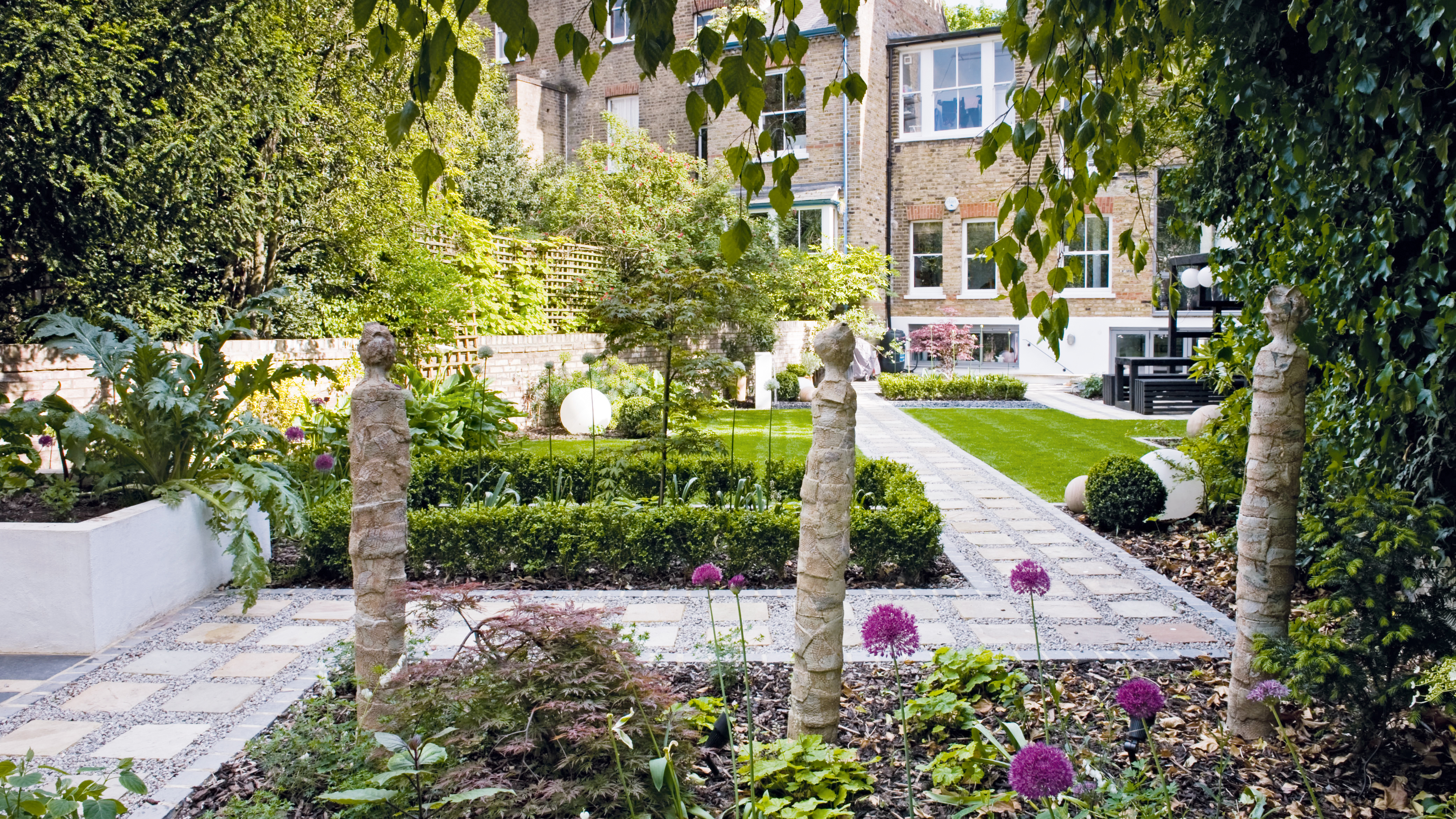 Contemporary garden with straight paths and lawns