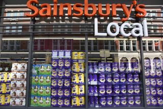 The front of a Sainsbury's local with rows of Easter eggs in the window