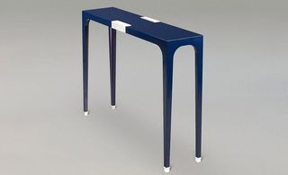blue console table has lacquered feet and details in bronze and matt nickel