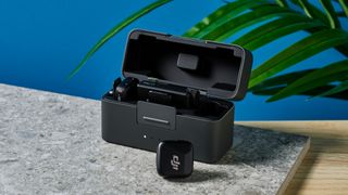 The DJI Mic Mini in black on a stone surface.