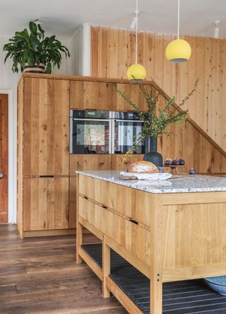 wooden kitchen with full-height units and built-in double ovens