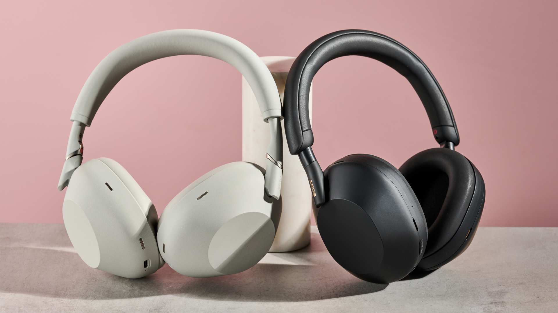 Sony WH-1000XM6 and Sony WH-1000XM5 leaning against pole