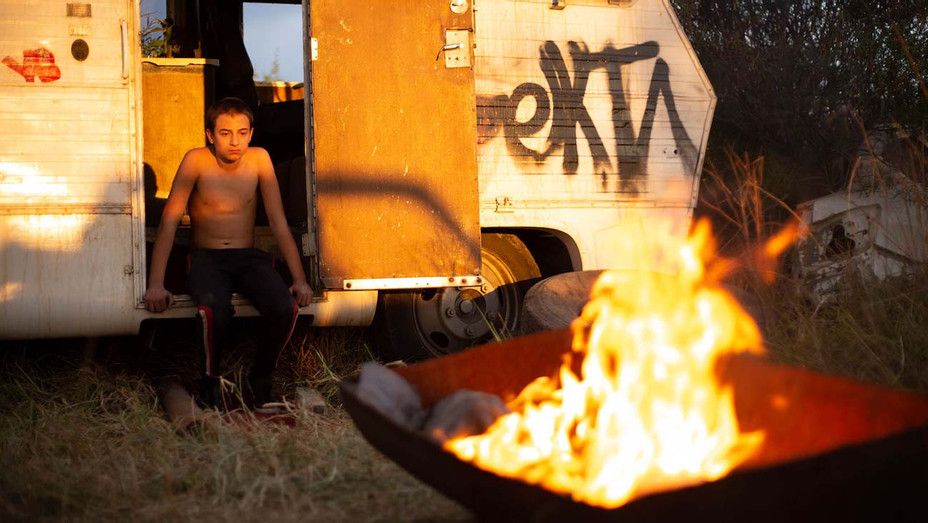 Rodrigo sits in front of a fire