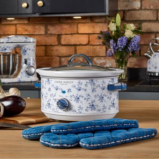 slow cooker with blue and white floral pattern on kitchen worktop with oven gloves