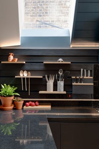 A close up shot of cantilevered shelves against black wall panels