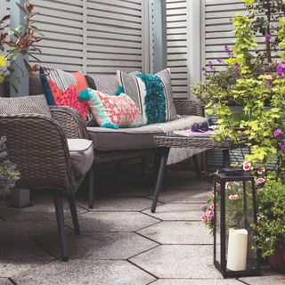 A patio with an outdoor seating set with colourful cushions