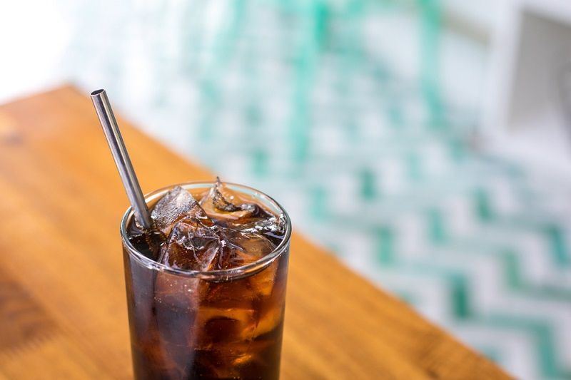 A reusable metal straw in a glass.