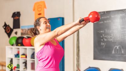 woman learning how to do kettlebell swings