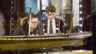 visitors looking at a model of the SS Great Britain