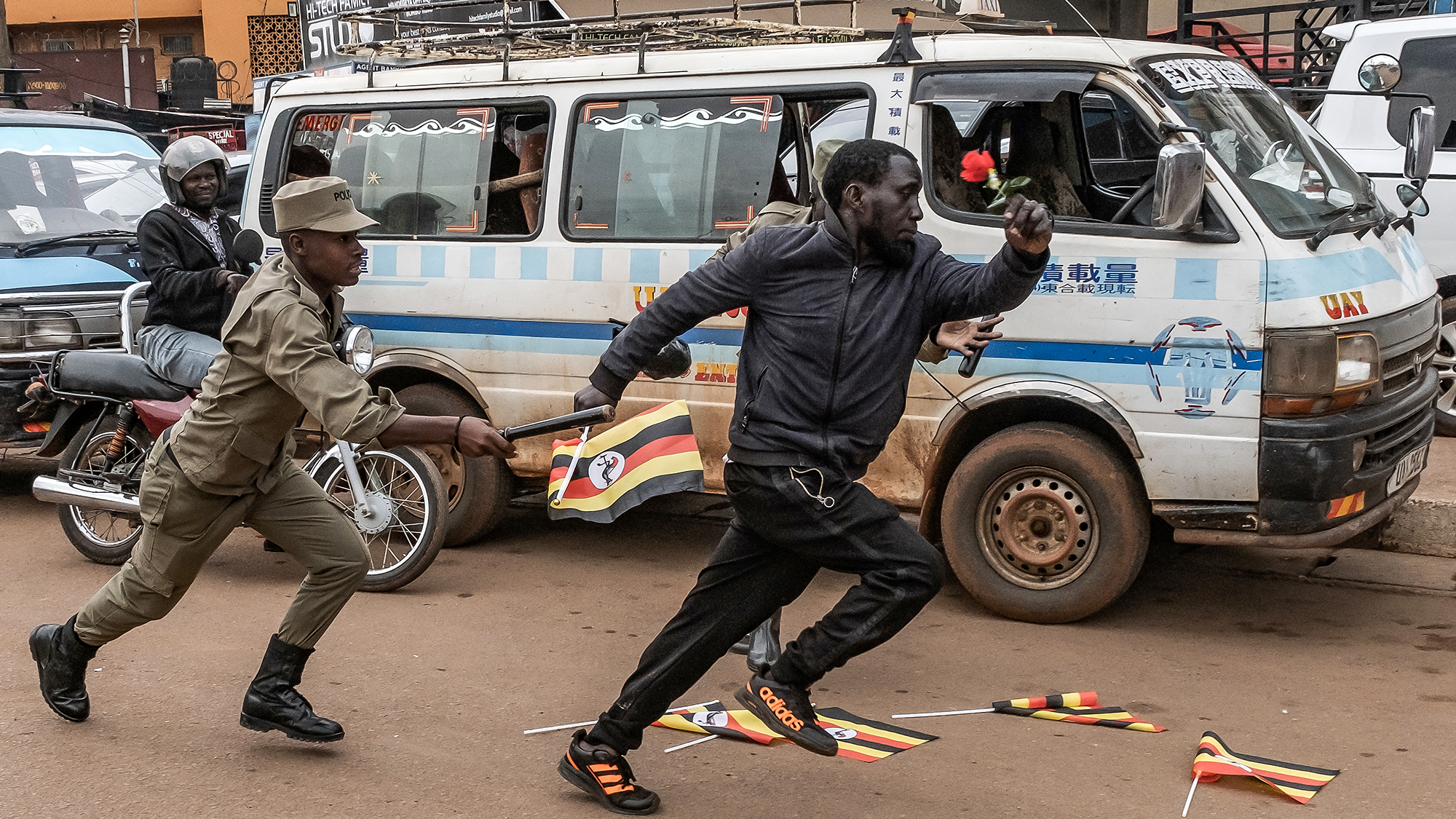 Police attempt to arrest a pro-opposition activist demonstrating against alleged election fraud in Kampala, Uganda