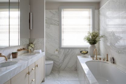 marble bathroom with big window and brass fittings