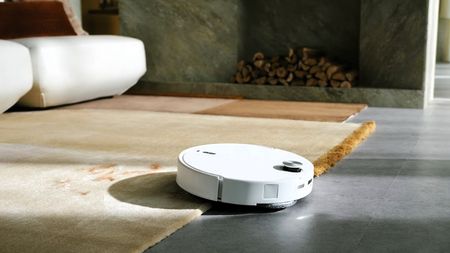 Roborock Qrevo Curv 2 Pro transitioning between a rug and hard floor